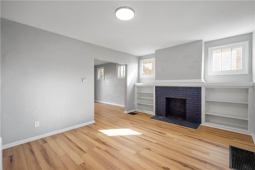 243 Castle Shannon Boulevard, Unit 243 Pittsburgh, PA 15228 - Photo 5 of 26 wooden floor fireplace and windows in an empty room