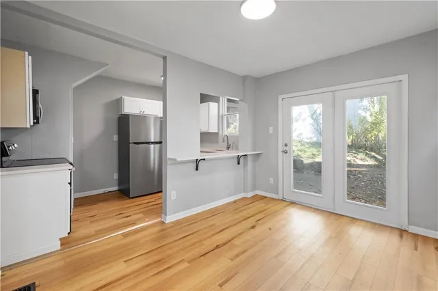 a view of empty room with wooden floor and window
