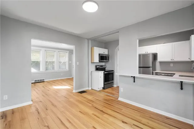 a view of kitchen with wooden floor and electronic appliances