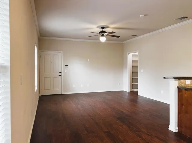 a view of an empty room with wooden floor