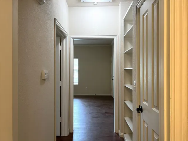 a view of a hallway with wooden floor and closet area