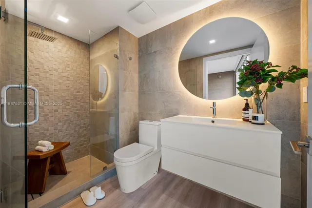 a bathroom with a sink a toilet and shower