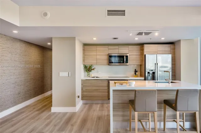 a kitchen with stainless steel appliances granite countertop a stove a sink and a refrigerator