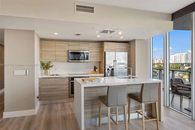 a kitchen with kitchen island granite countertop a stove and a refrigerator