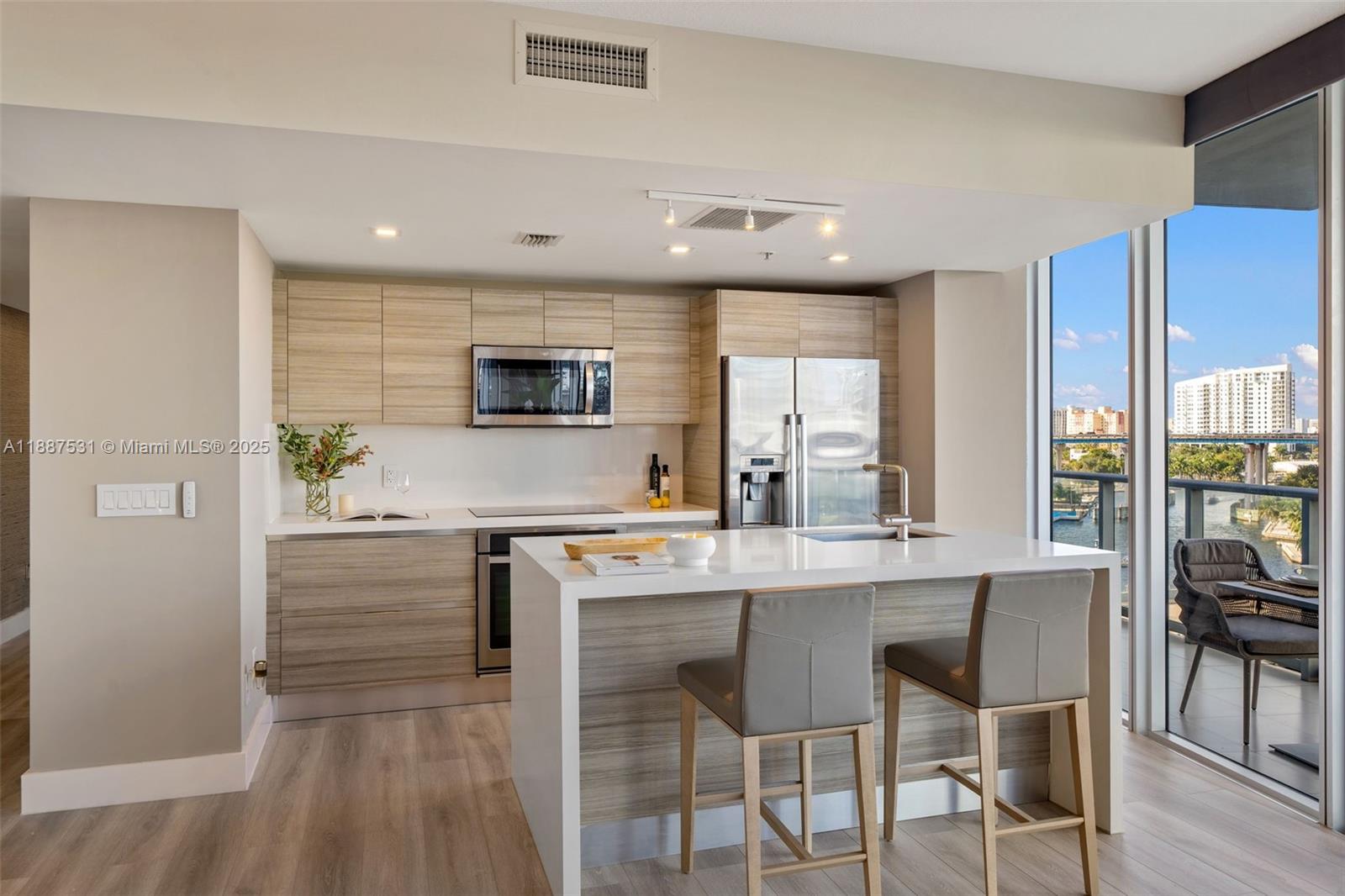 185 Southwest 7th Street, Unit 803 Miami, FL 33130 - Photo 7 of 25 a kitchen with kitchen island granite countertop a stove and a refrigerator