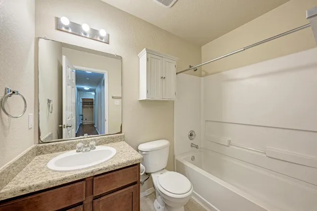 a bathroom with a granite countertop sink toilet and shower