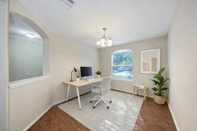a view of a workspace with furniture and a window