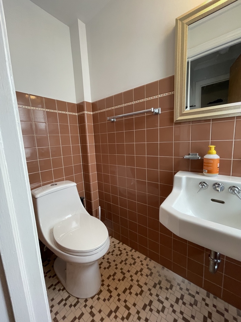Undisclosed Address Oak Park, IL 60302 - Photo 7 of 15 a bathroom with a toilet a sink and mirror