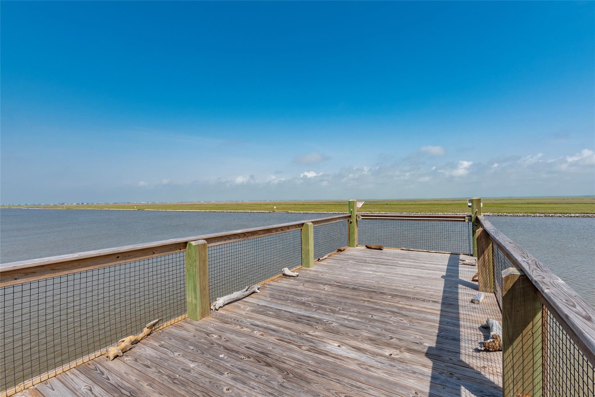 1453 County Road 230 Sargent, TX 77414 - Photo 27 of 38 Upper Deck — Enjoy breathtaking views of the Intracoastal Waterway, Beach, and protected wetlands from this spacious deck. A perfect place to relax, watch dolphins play, observe coastal wildlife, and take in the unobstructed natural scenery of the wetlands across the water.