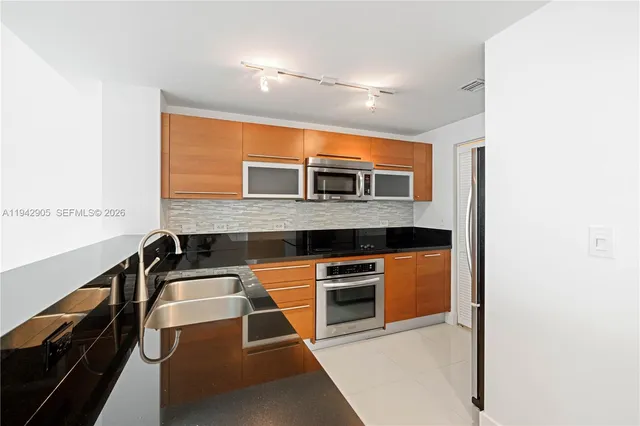 a kitchen with stainless steel appliances granite countertop a sink and a stove
