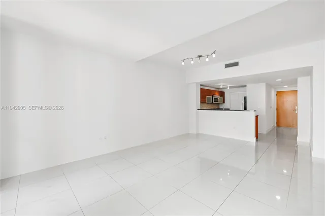 an empty room with a cabinet and mirrors