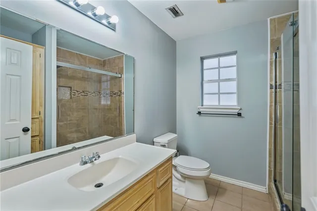 a bathroom with a toilet a sink a mirror and vanity