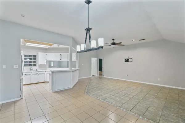 a view of a kitchen with kitchen island stainless steel appliances cabinets a sink and a counter top