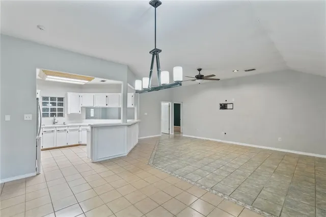a view of a kitchen with kitchen island stainless steel appliances cabinets a sink and a counter top