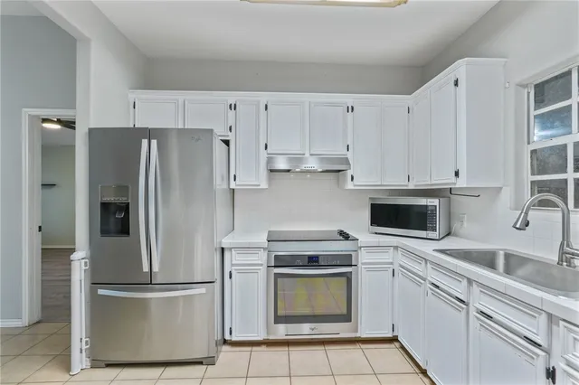 a kitchen with cabinets stainless steel appliances and a counter space