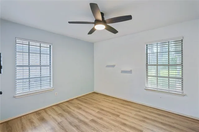 a view of empty room with wooden floor and window