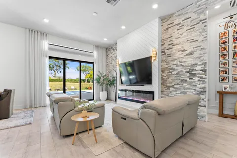 a kitchen with stainless steel appliances kitchen island granite countertop a stove a sink dishwasher a refrigerator and a dining table with wooden floor