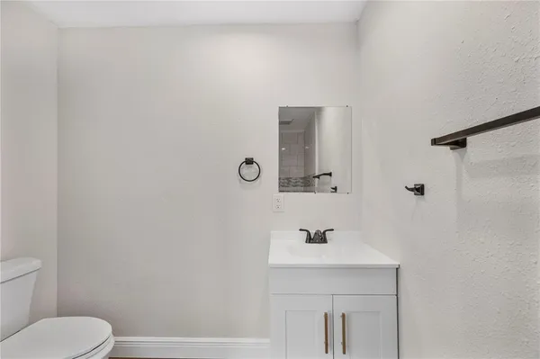 a bathroom with a sink toilet and mirror