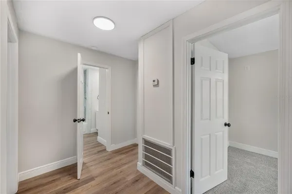 a view of a hallway with wooden floor and closet area