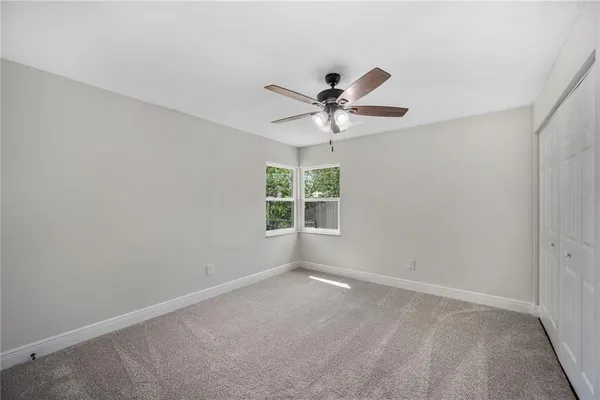 an empty room with a window and a fan