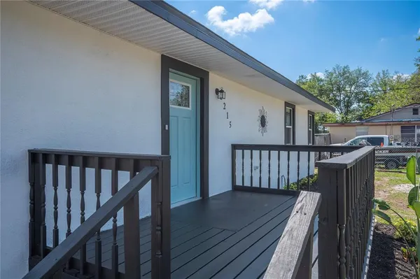 a view of balcony with wooden floor and fence and a barbeque