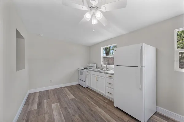 a kitchen with cabinets wooden floor and stainless steel appliances
