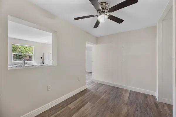 an empty room with a window and a ceiling fan