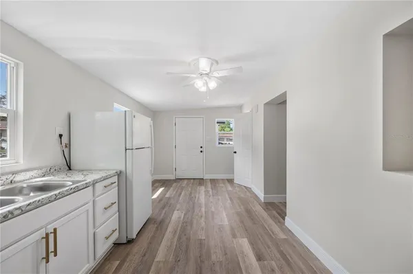 a kitchen with a sink and wooden floor