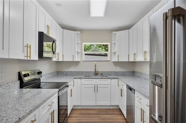 a kitchen with stainless steel appliances granite countertop a sink stove and cabinets