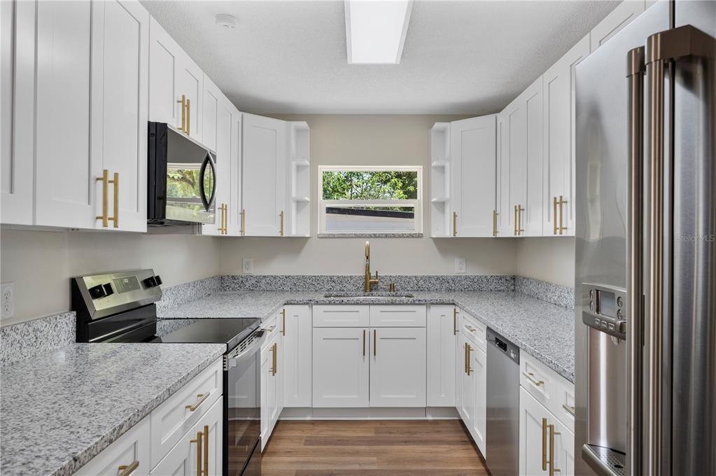 1215 El Camino Road Lakeland, FL 33805 - Photo 5 of 34 a kitchen with stainless steel appliances granite countertop a sink stove and cabinets
