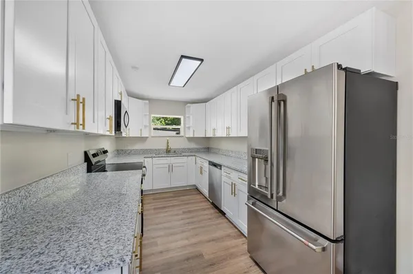 a kitchen with stainless steel appliances a refrigerator sink and cabinets