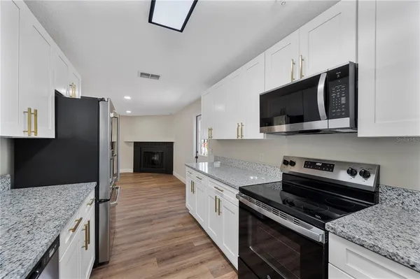a large kitchen with a stove and a microwave
