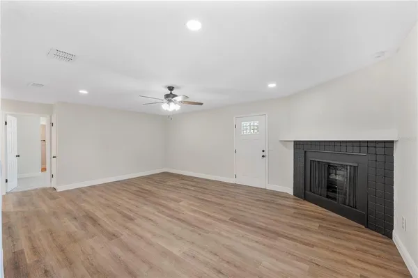 an empty room with fan and a fireplace