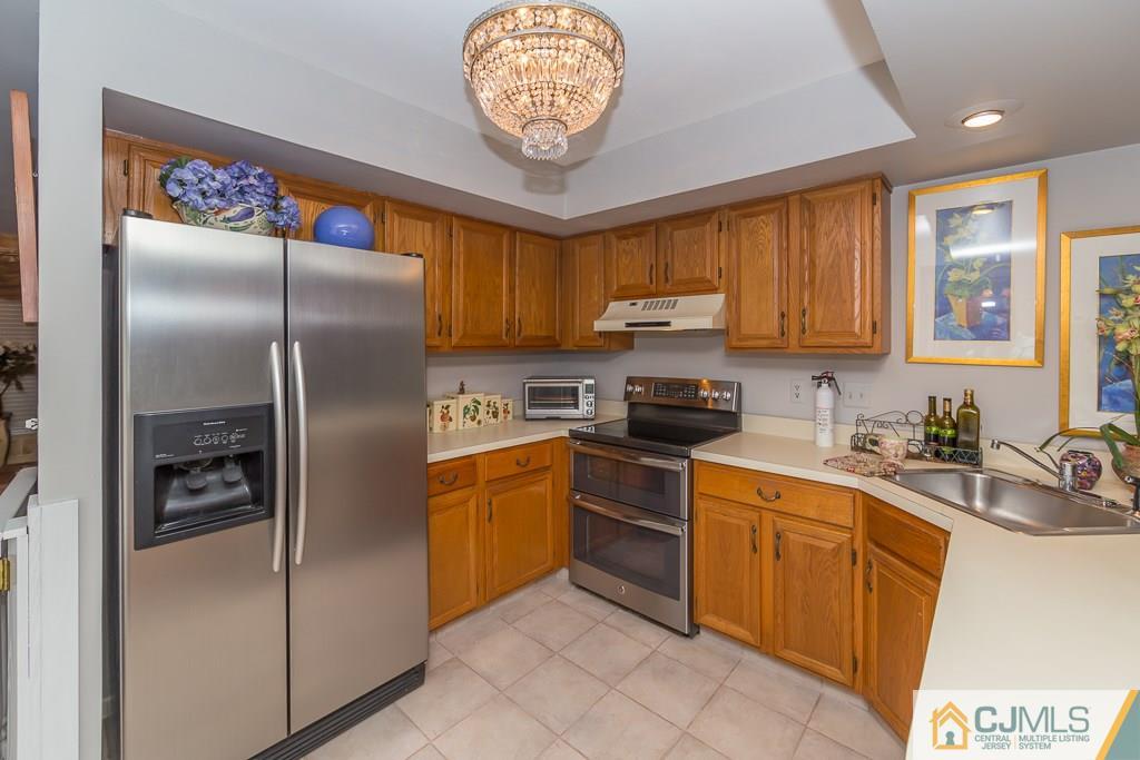 57 Fieldstone Road Bedminster, NJ 07921 - Photo 5 of 22 a kitchen with stainless steel appliances granite countertop a refrigerator a sink a stove with wooden cabinets