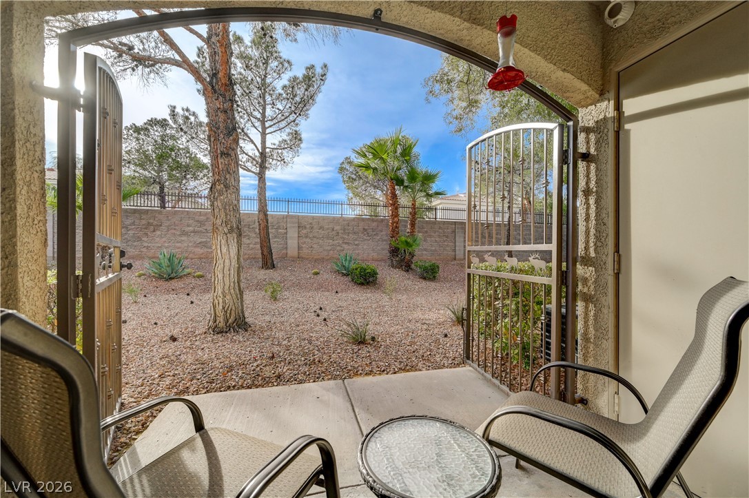 7885 West Flamingo Road, Unit 1071 Las Vegas, NV 89147 - Photo 25 of 28 Gated patio provides private access to a low-maintenance yard with desert landscaping and a privacy wall.