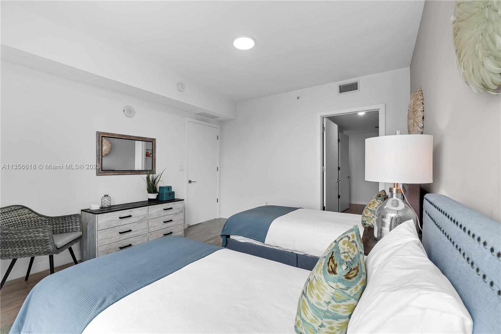 3900 Biscayne Boulevard, Unit S320 Miami, FL 33137 - Photo 14 of 42 a bedroom with two beds and a lamp