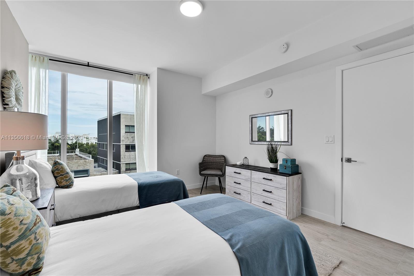 3900 Biscayne Boulevard, Unit S320 Miami, FL 33137 - Photo 15 of 42 a bedroom with two beds and large windows