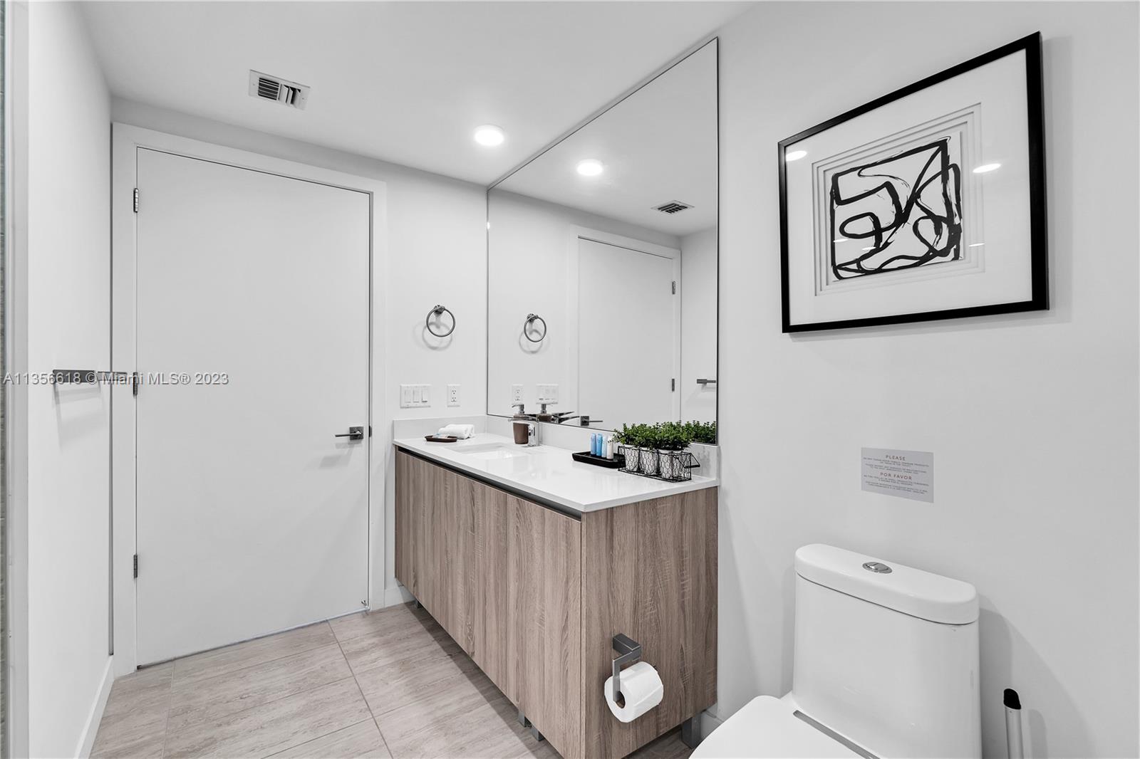 3900 Biscayne Boulevard, Unit S320 Miami, FL 33137 - Photo 17 of 42 a bathroom with a sink mirror and toilet