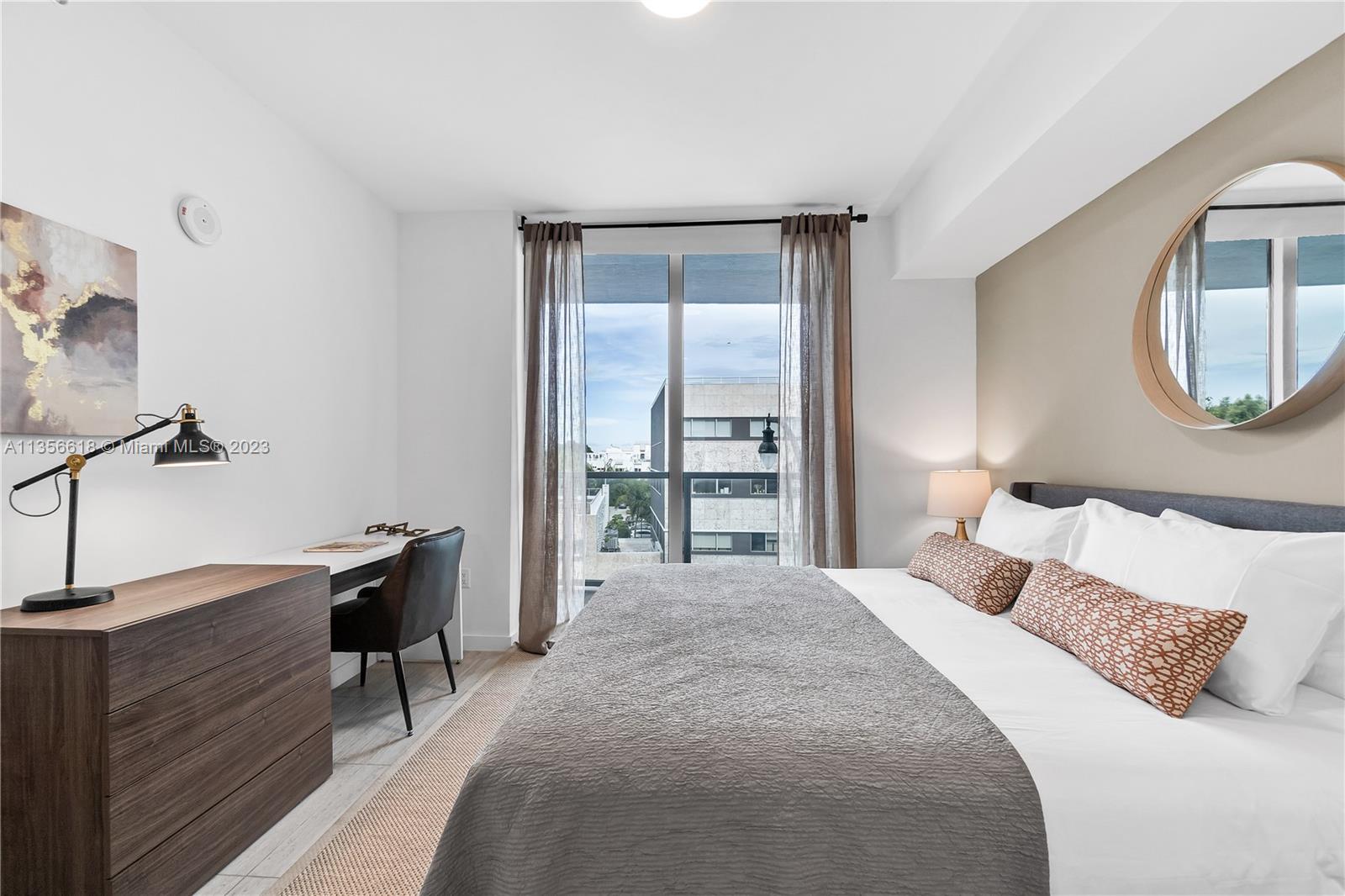 3900 Biscayne Boulevard, Unit S320 Miami, FL 33137 - Photo 23 of 42 a bedroom with a bed a desk and chair with mirror