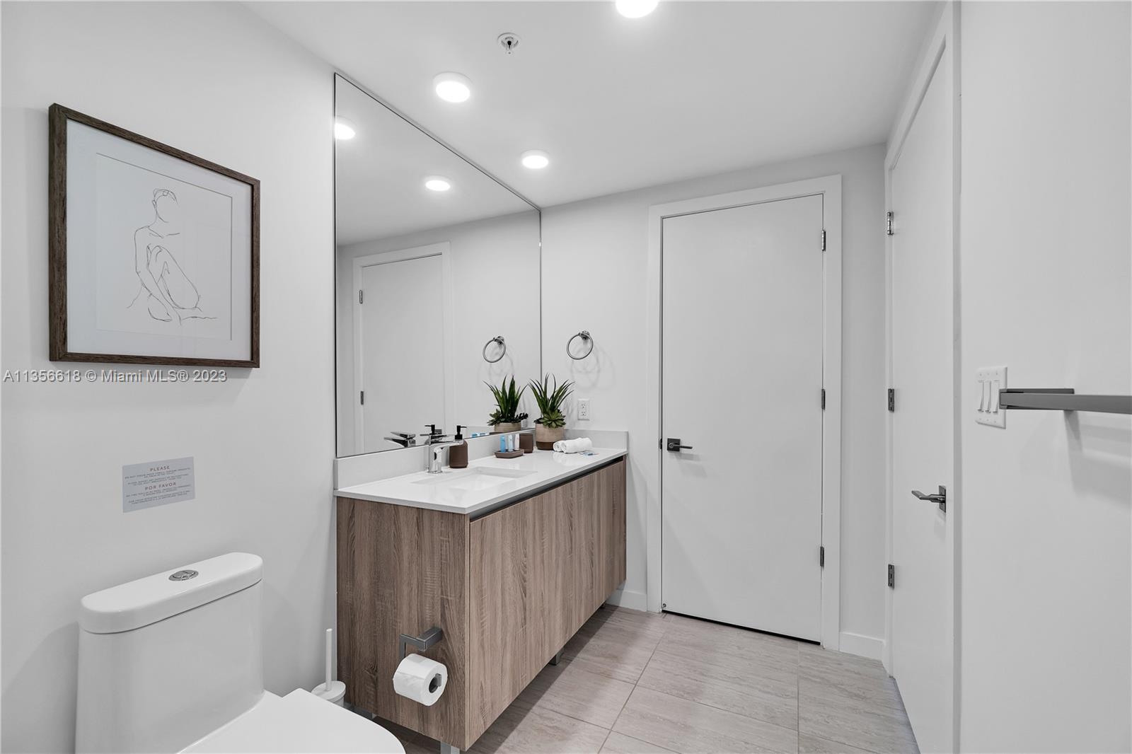 3900 Biscayne Boulevard, Unit S320 Miami, FL 33137 - Photo 27 of 42 a bathroom with a toilet a sink and mirror