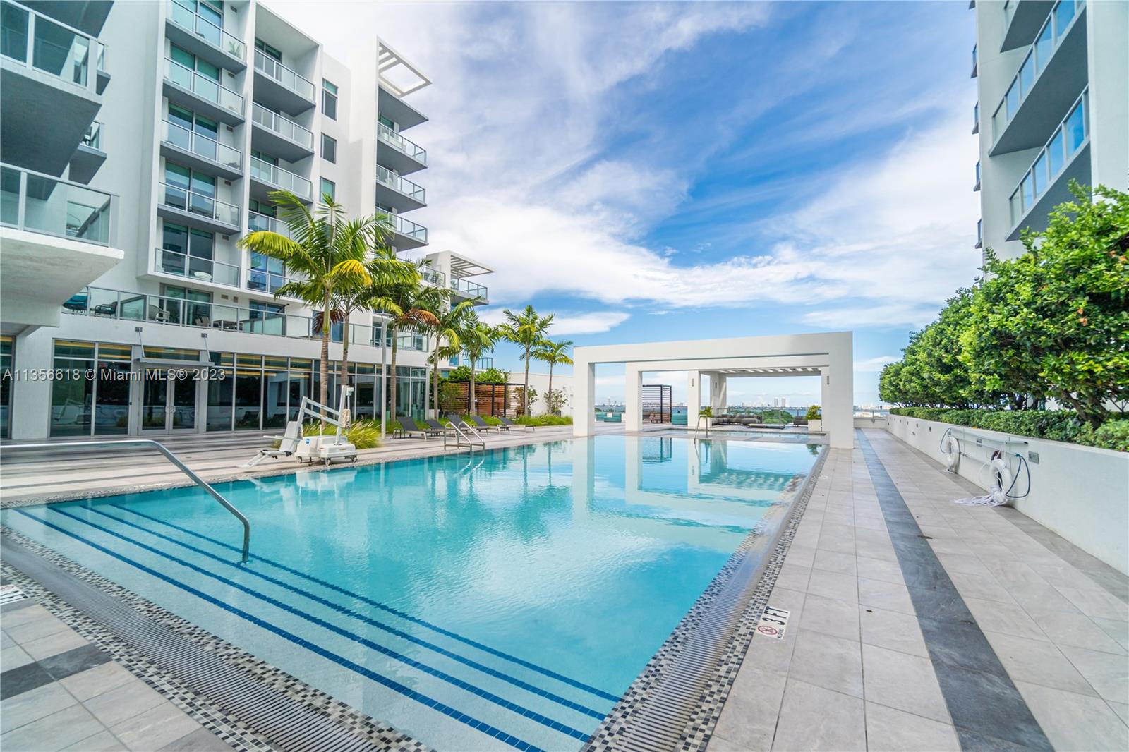 3900 Biscayne Boulevard, Unit S320 Miami, FL 33137 - Photo 38 of 42 a view of a swimming pool with a lounge chairs