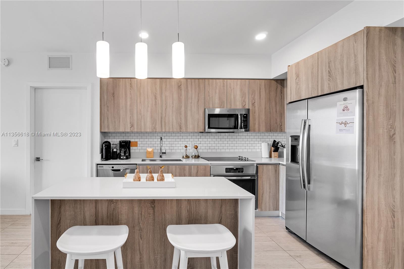 3900 Biscayne Boulevard, Unit S320 Miami, FL 33137 - Photo 7 of 42 a kitchen with stainless steel appliances a sink a microwave a refrigerator and cabinets