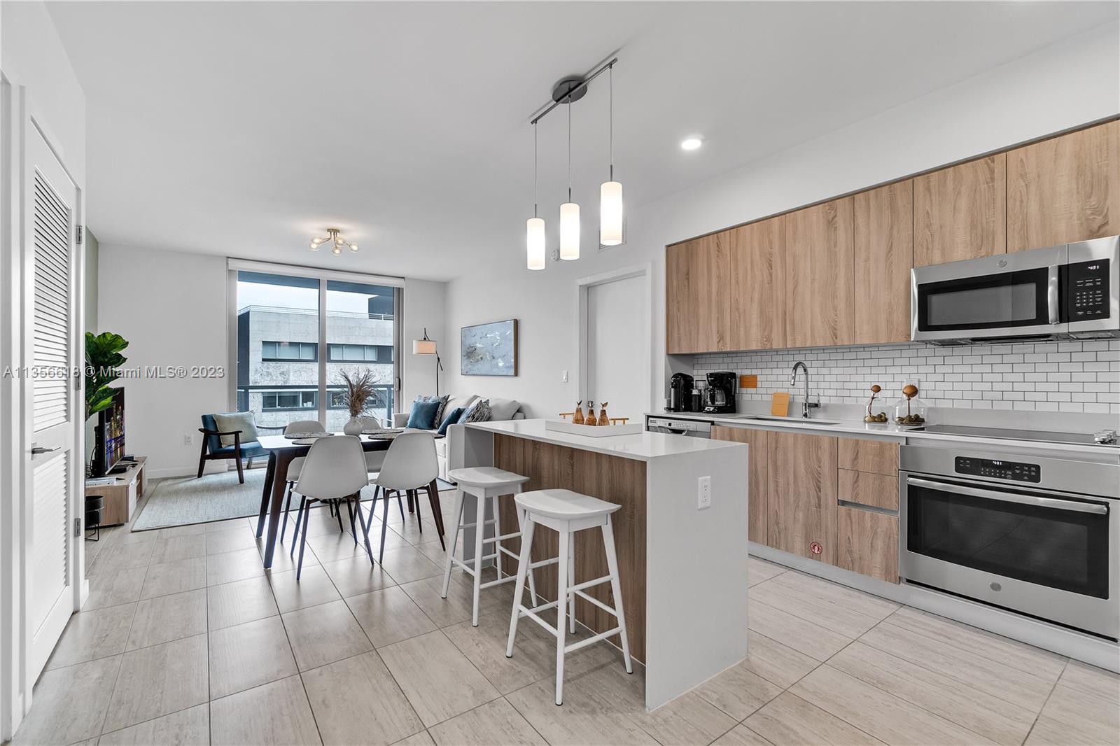 3900 Biscayne Boulevard, Unit S320 Miami, FL 33137 - Photo 8 of 42 a large kitchen with a table and chairs