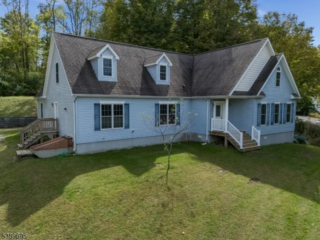 a view of a house with a big yard plants and large trees