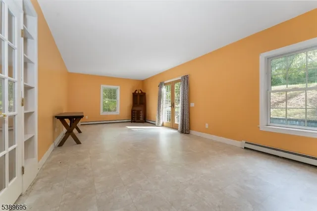 a view of an empty room with a birdcage and a window