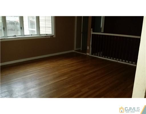 135 Princeton Road Old Bridge, NJ 08859 - Photo 5 of 7 a open area with wooden floor and a black gate