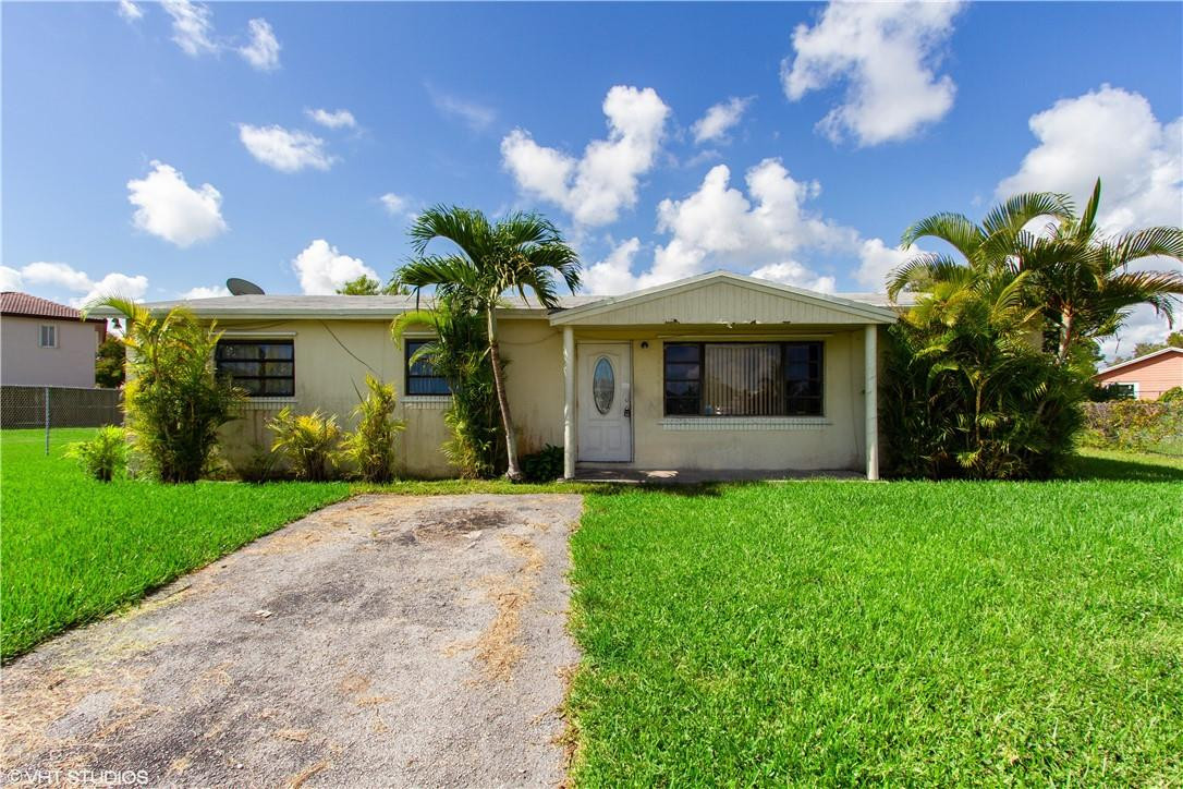 11398 Southwest 227th Terrace Miami, FL 33170 - Photo 1 of 13 a front view of a house with garden