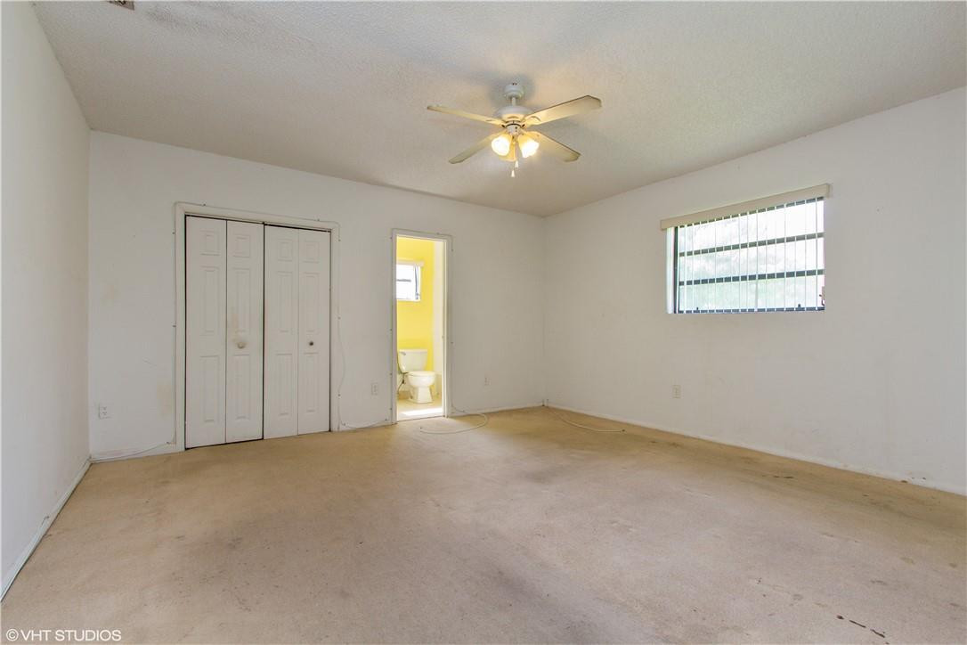 11398 Southwest 227th Terrace Miami, FL 33170 - Photo 5 of 13 an empty room with chandelier fan and windows