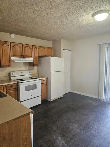 a kitchen with a refrigerator stove and white cabinets