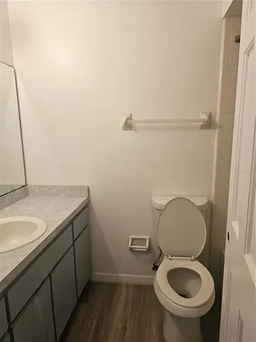 a bathroom with a granite countertop toilet and a sink